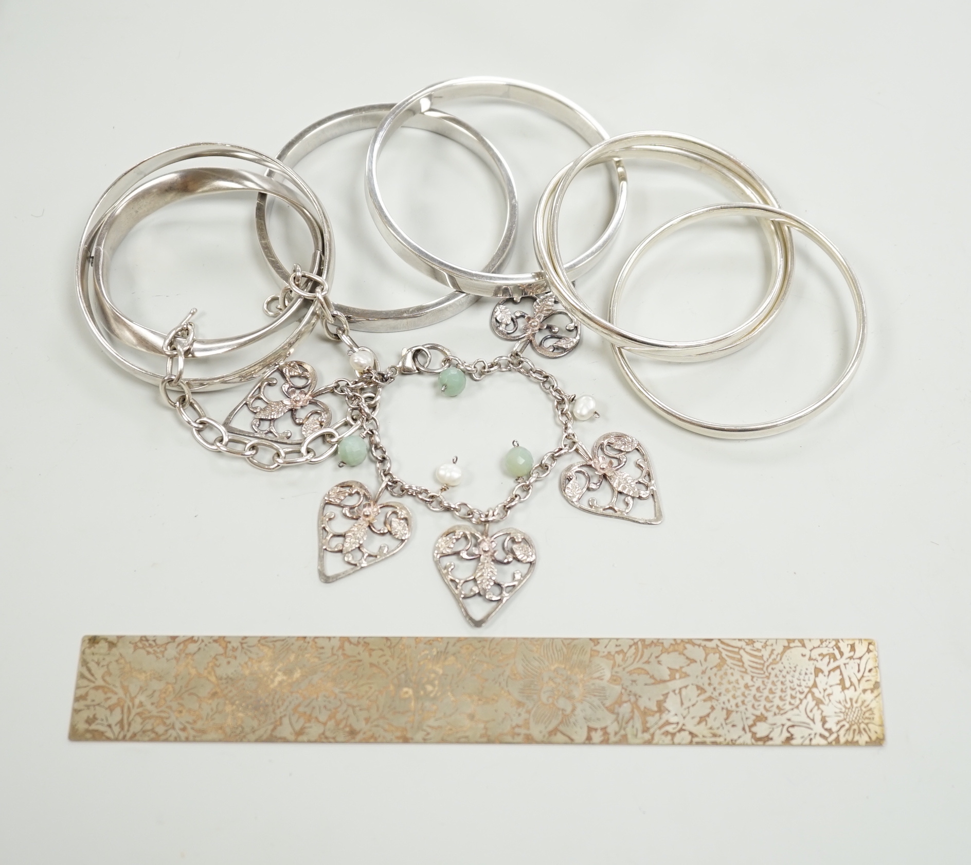 Three Pruden Smith bangles including triple loop, two other silver bangles, a white metal heart bracelet and one other bracelet, together with a straight edge rule by Mary Ann Simmons.